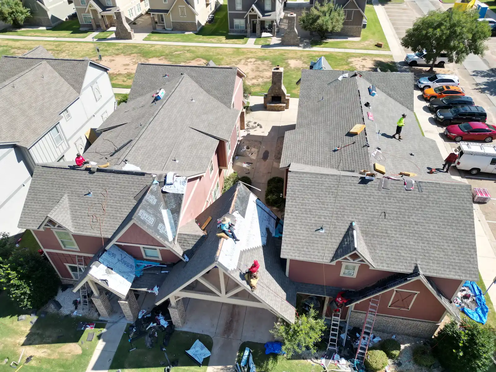 Aerial view roofing crew reroofing homes